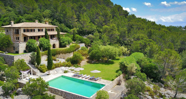 Sky view of Can Montana, a private villa in Italy. The villa is surrounded by trees and has a steps leading down to a plunge pool.