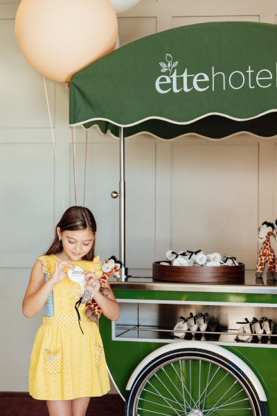 child eating from a cart with the ette hotel logo on it